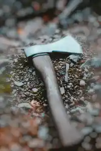 A hatchet laying on pebbled ground